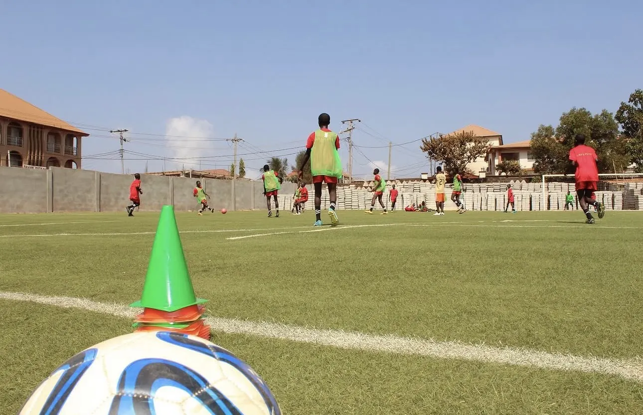 Wide view of a Loma Academy training session on the artificial pitch in Calaba Town, Freetown